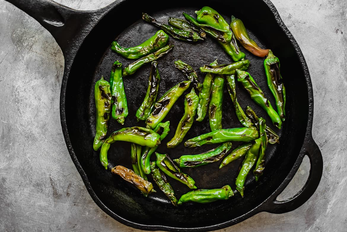 Blsitered Shishito Peppers in cast iron skillet