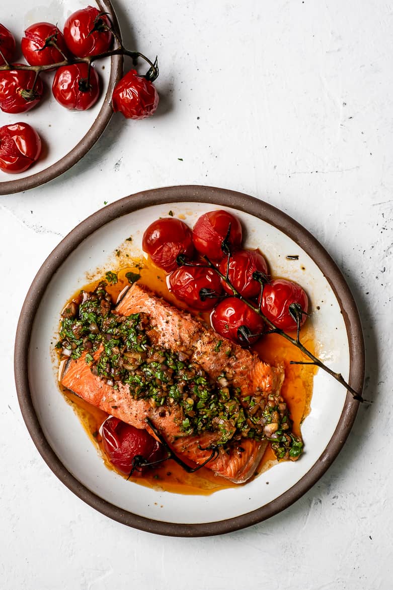 Baked Salmon topped with red chimichurri sauce and baked cherry tomatoes on the side