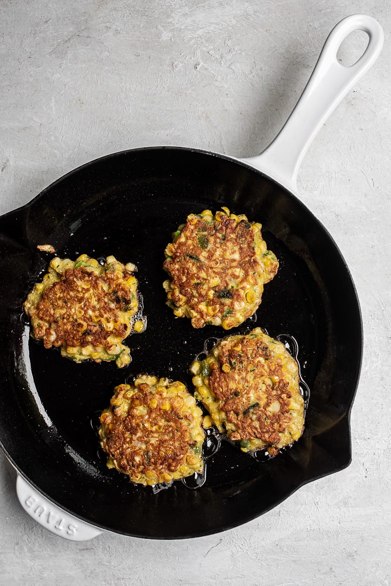 Corn and Poblano Fritters frying on skillet