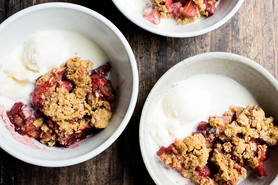 Strawberry- Rhubarb polenta crisp with ice cream in bowls