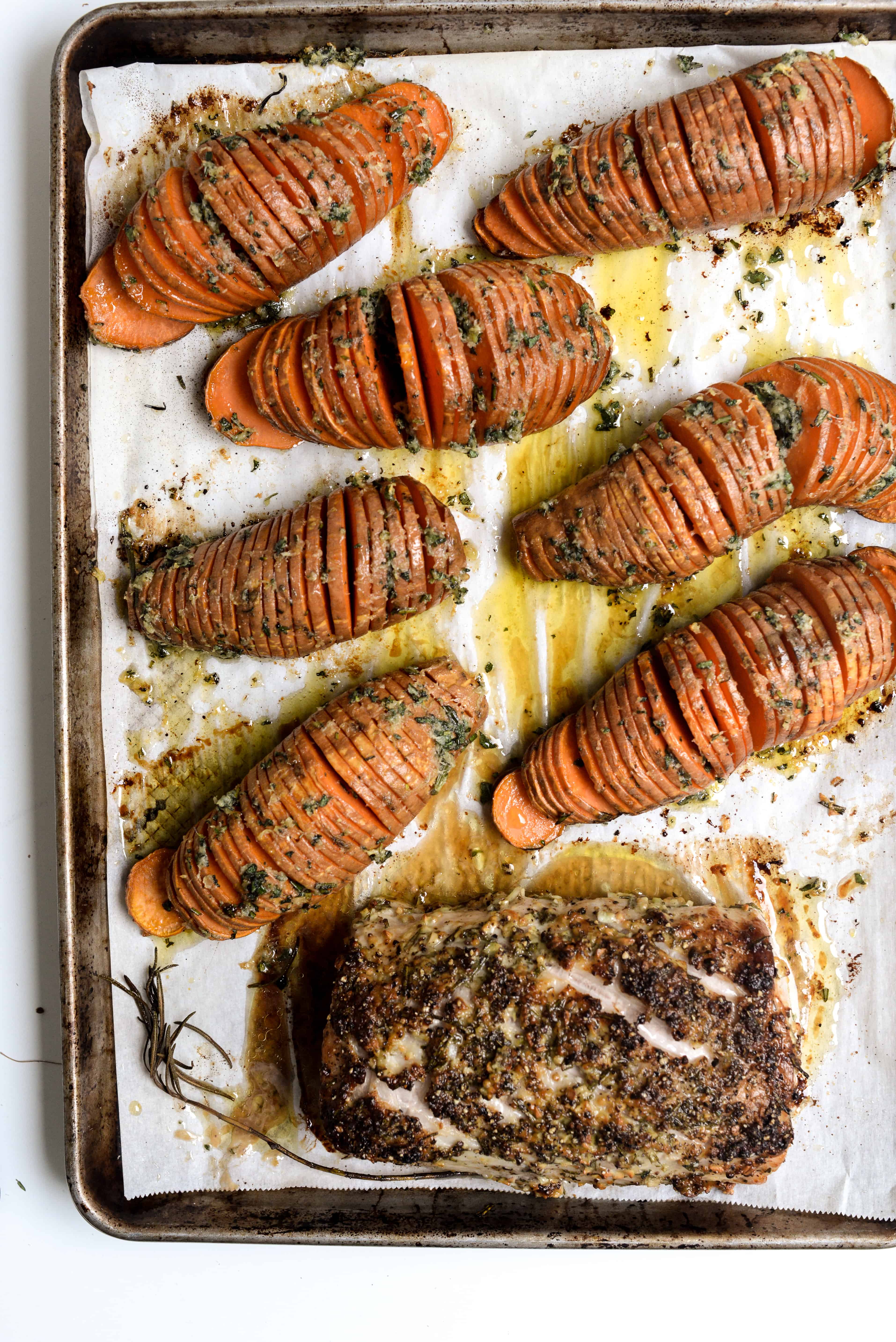 Cooked sweet potatoes and pork on sheet pan