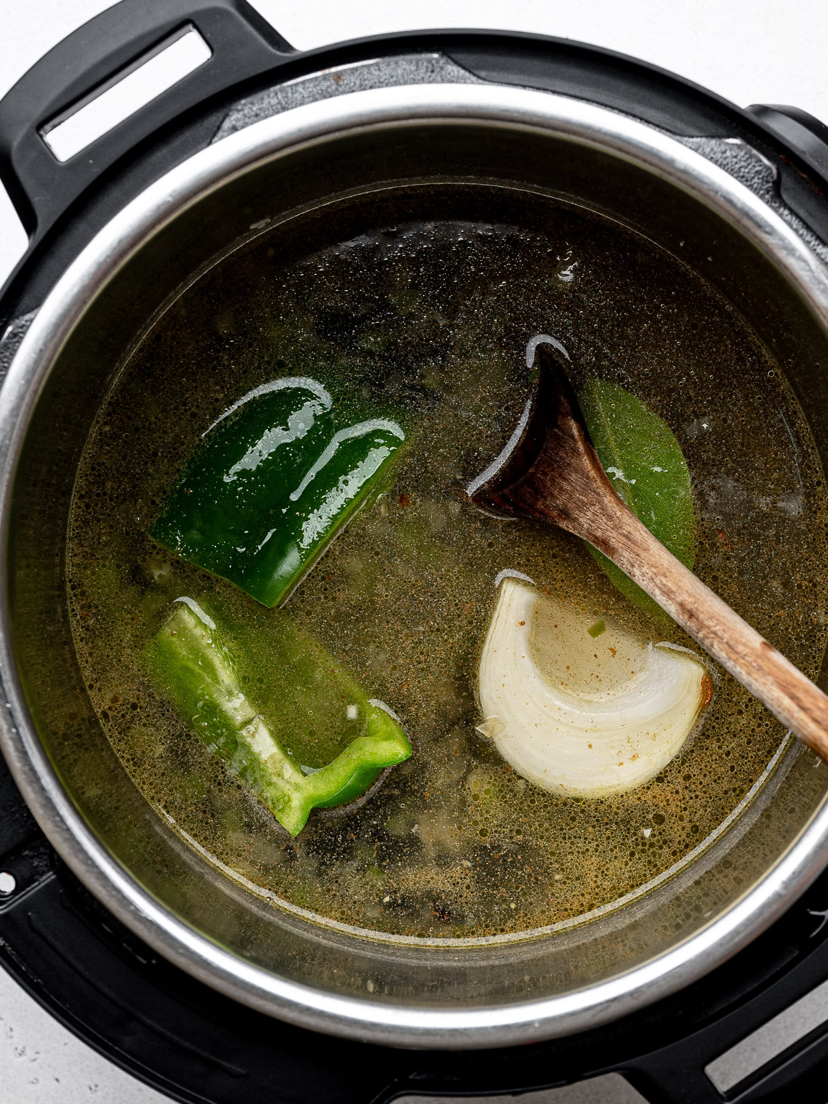 chunks of green pepper and onion added to the liquid and bean mixture in Instant pot