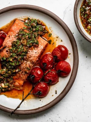 Baked Salmon topped with red chimichurri and extra chimichurri on the side