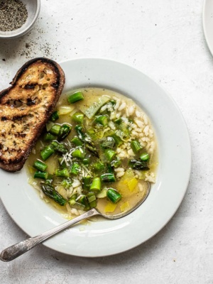 Asparagus and rice soup in bowl with crusty bread