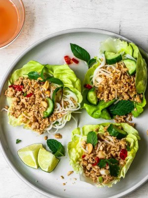 Chicken and Lettuce wraps on plate with nuoc cham sauce and cashews