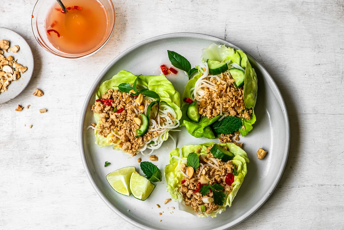 Chicken and Lettuce wraps on plate with nuoc cham sauce and cashews