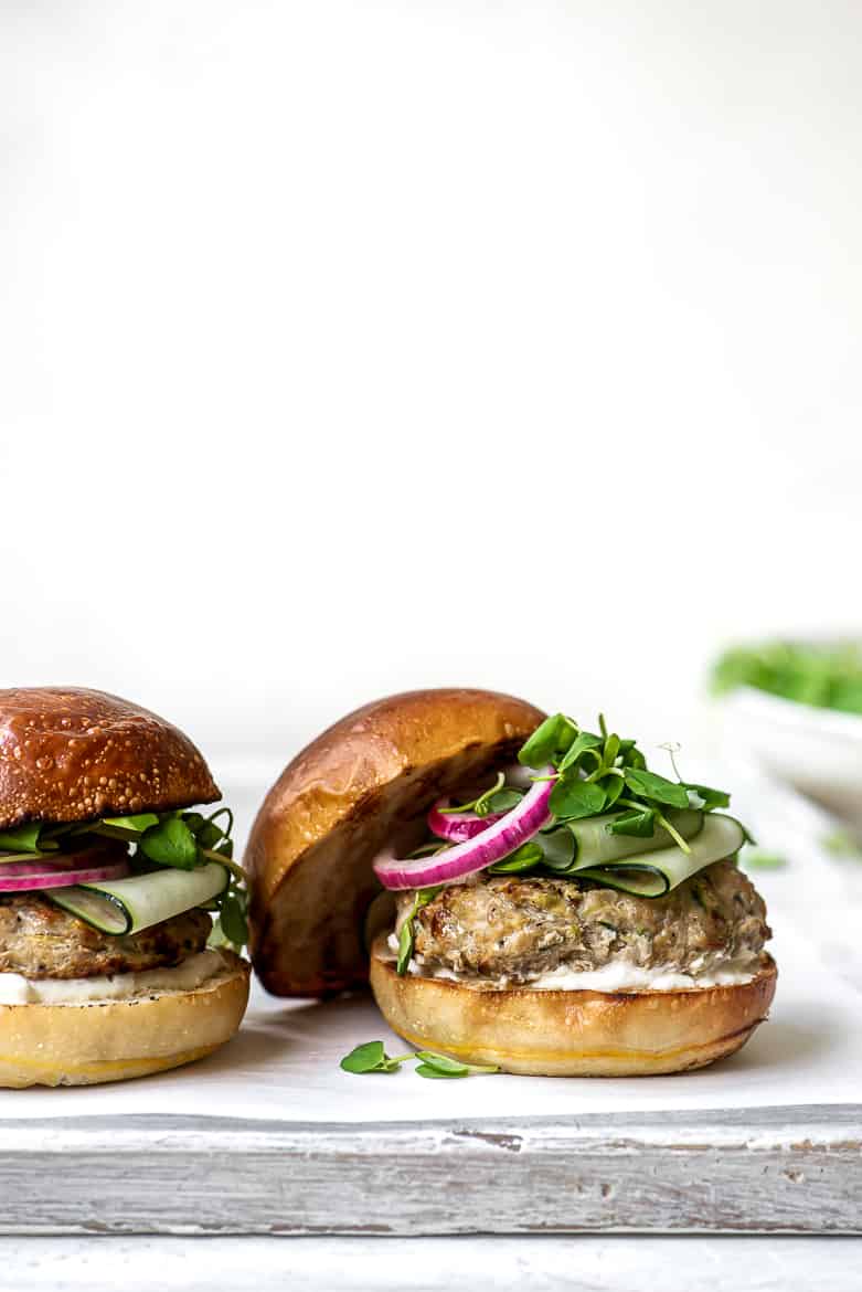 close up of two chicken burgers in a bun with toppings