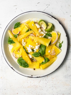 yellow watermelon and feta salad with red onion and basil leaves