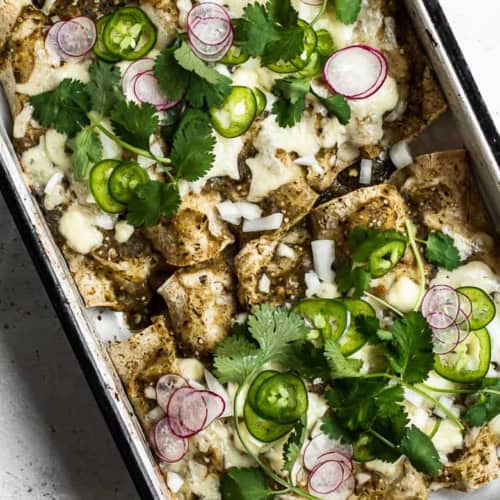 cooked enchiladas in casserole with toppings