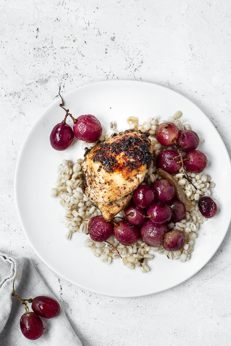 Chicken with grapes on plate