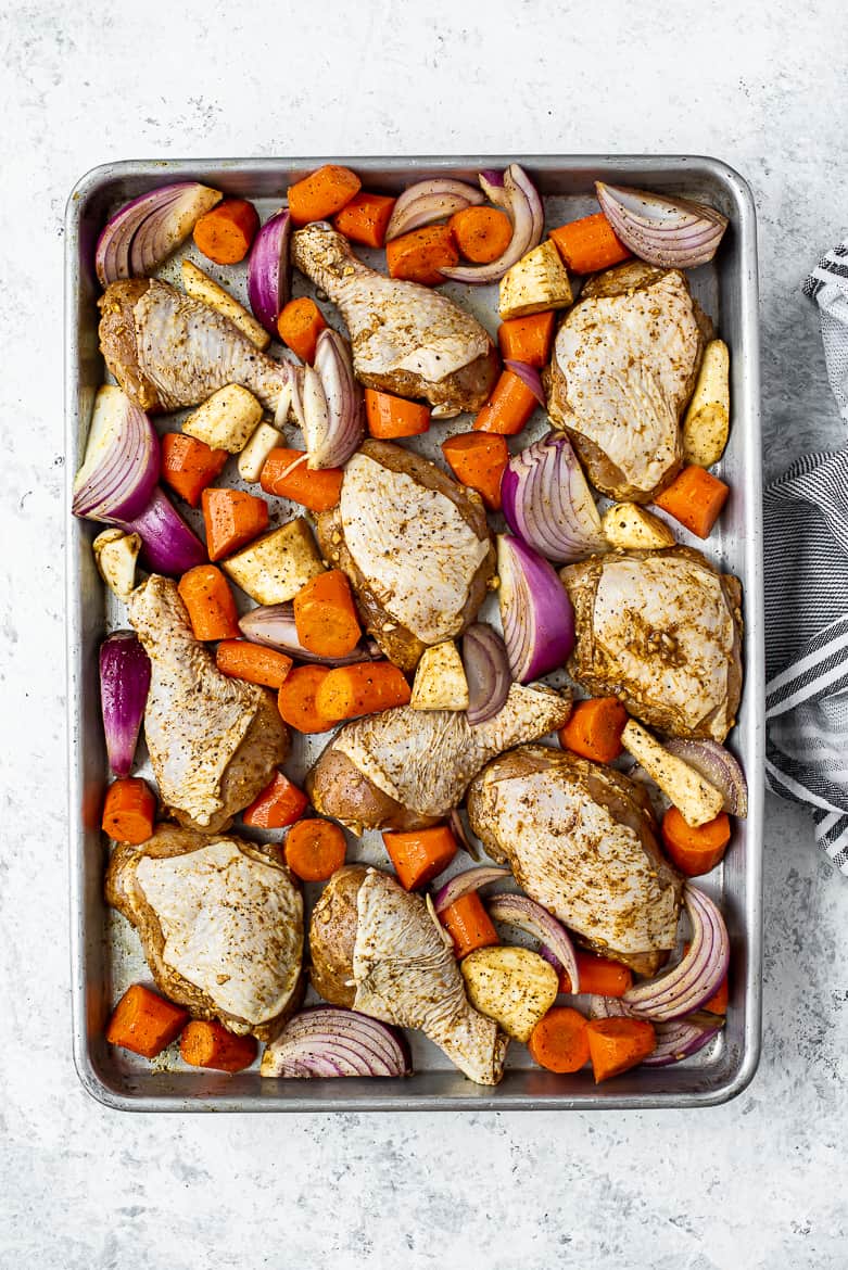 Prepared chicken and vegetables with Moroccan spices on a sheet pan 