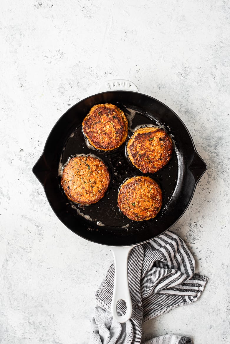 Pan-frying salmon cakes in skillet 