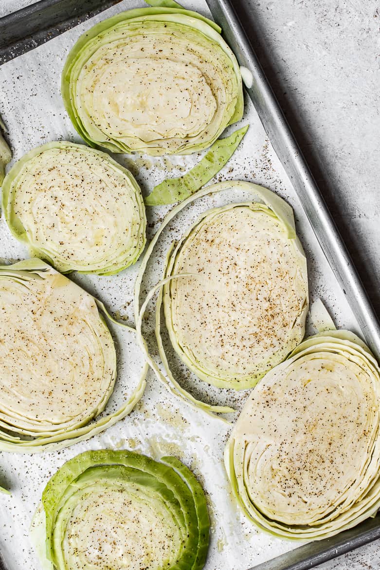 Green cabbage steaks on baking sheet