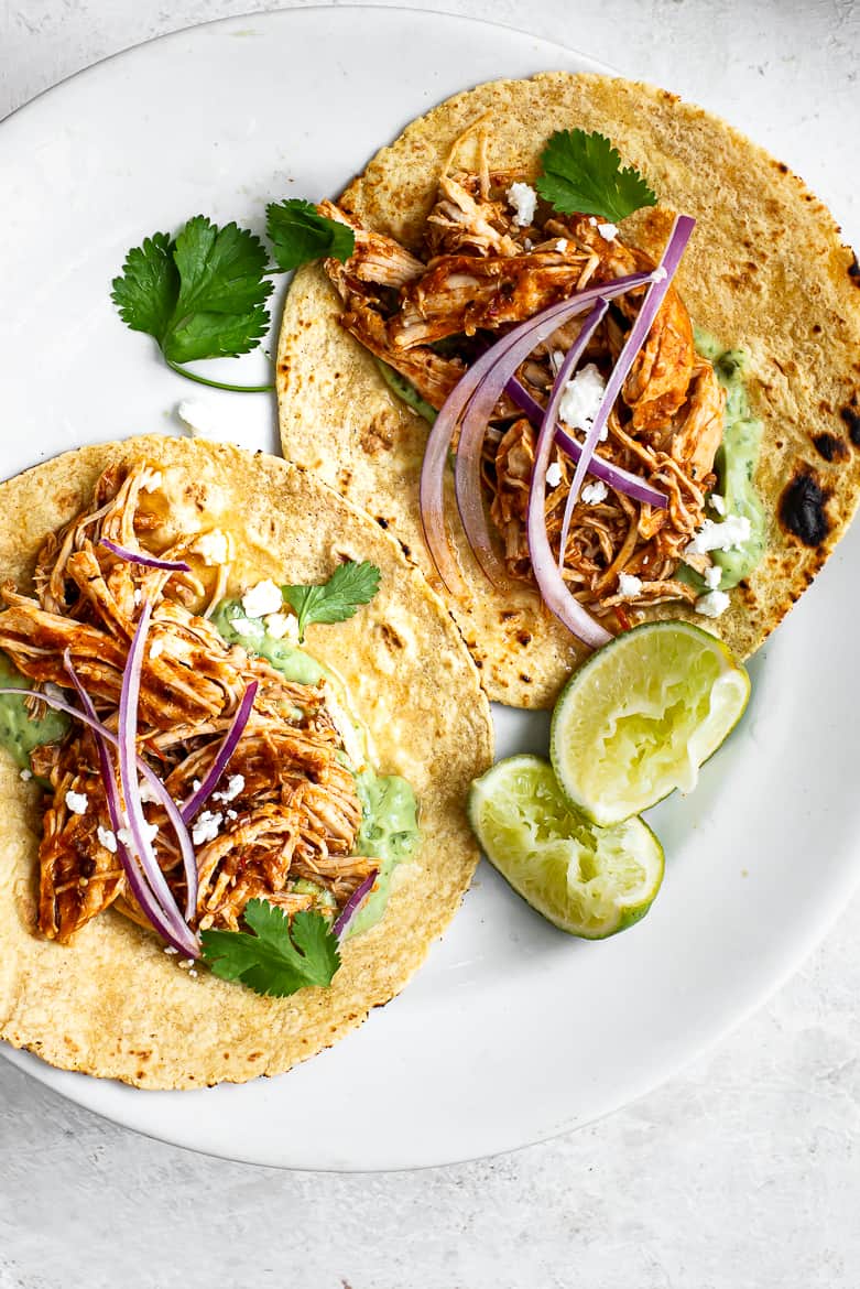 Close up of Chicken tinga in taco shells with avocado crema