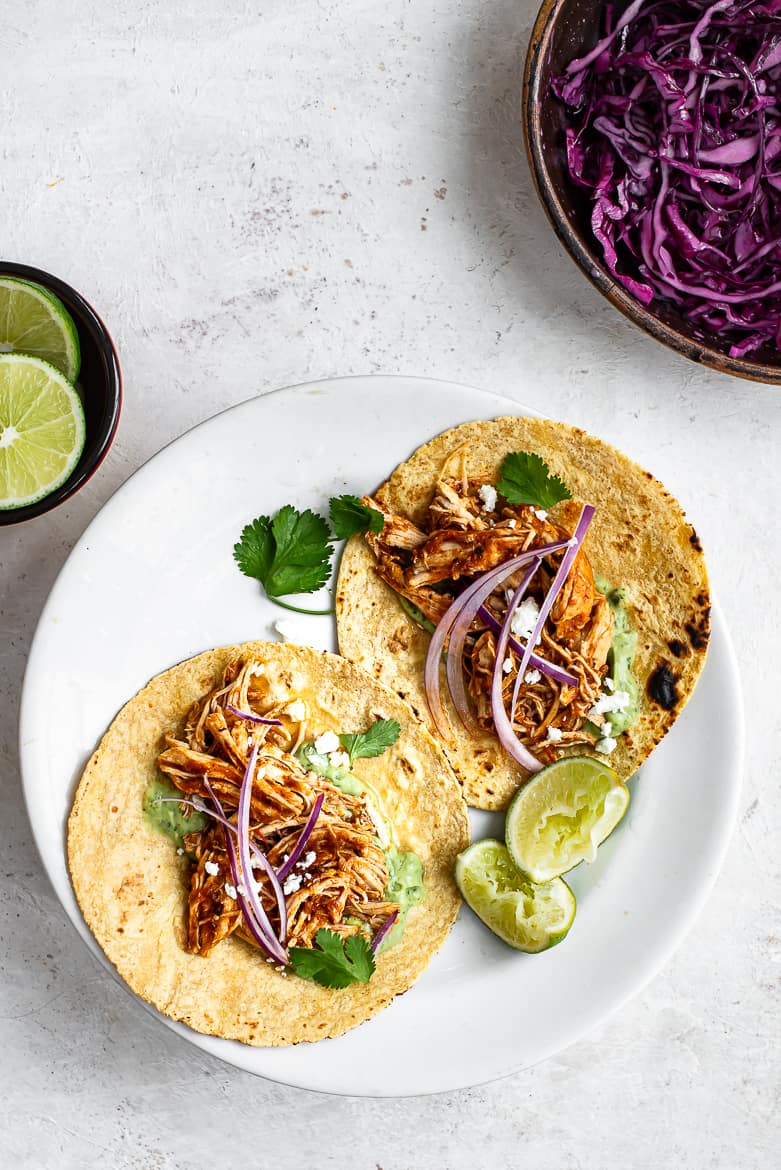 Chicken tinga in taco shells with avocado crema