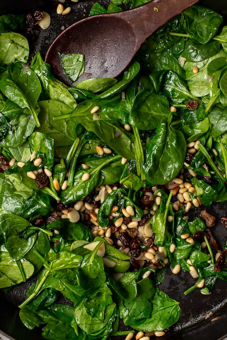 Close up of Catalan spinach, raisins and pine nuts on platter 