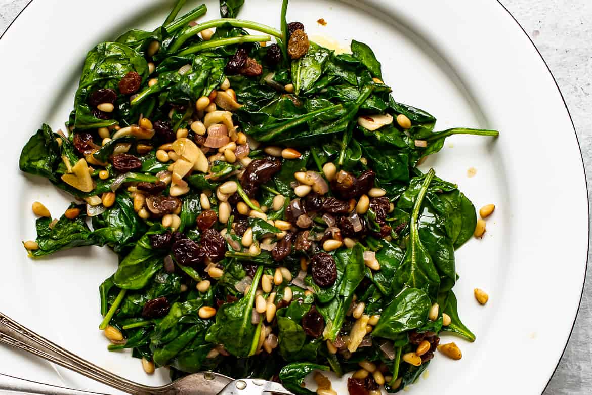 Close up of Catalan spinach, raisins and pine nuts on platter 