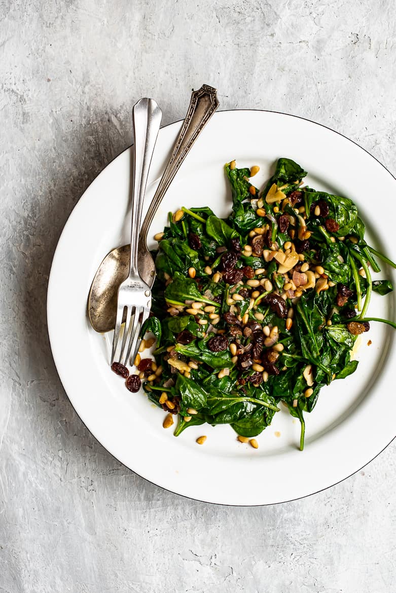 Sautéed spinach, raisins and pine nuts on platter 