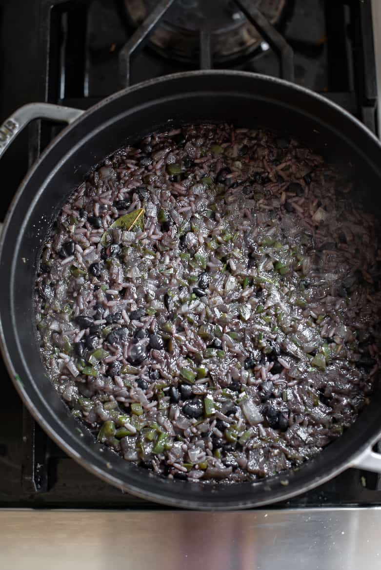 Rice and black beans simmering uncovered on stovetop