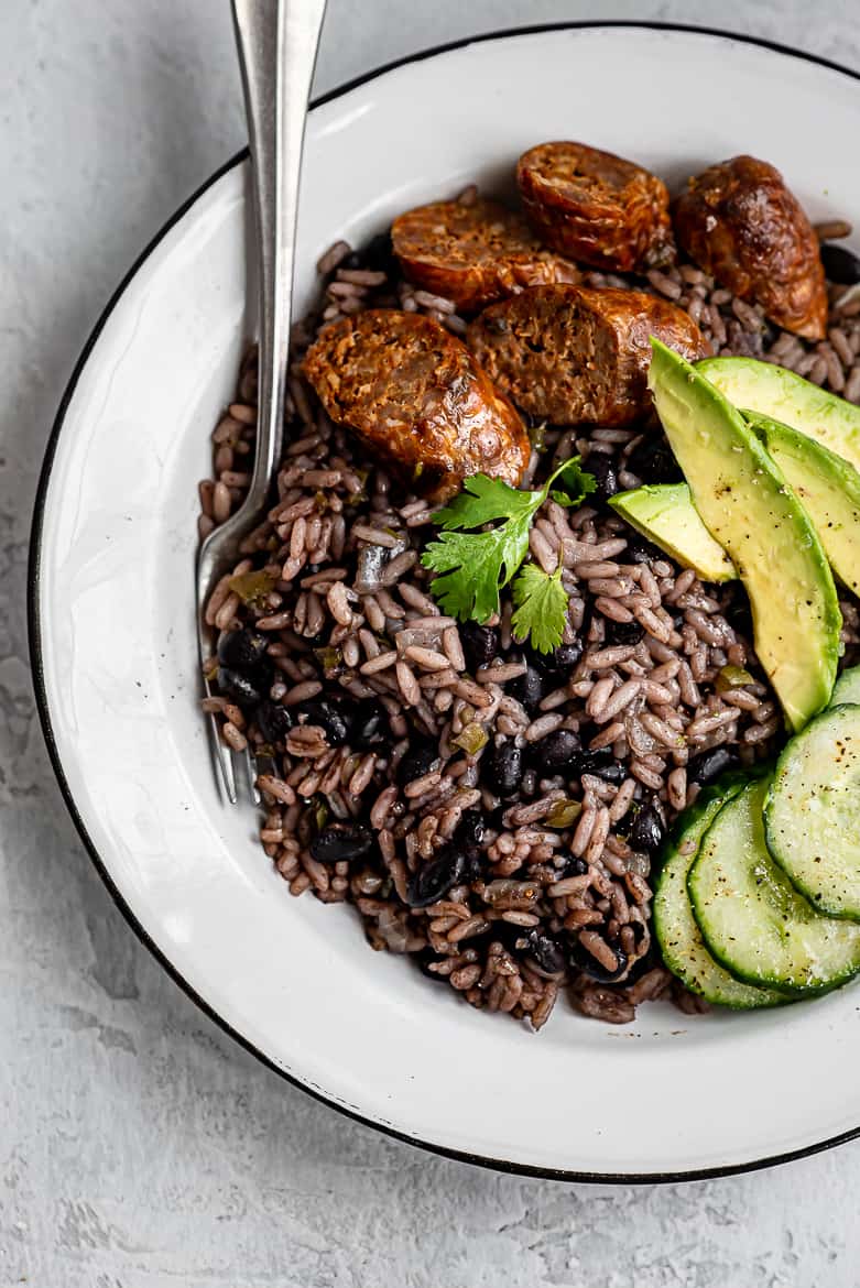 Moro negro served with avocados, sausage and cucumbers
