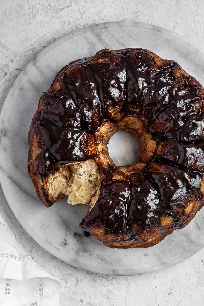 Chocolate monkey bread on platter with one piece missing