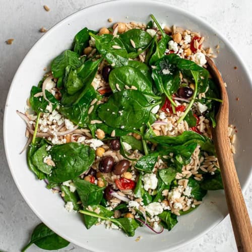 Warm Orzo and chickpea salad with spinach in bowl