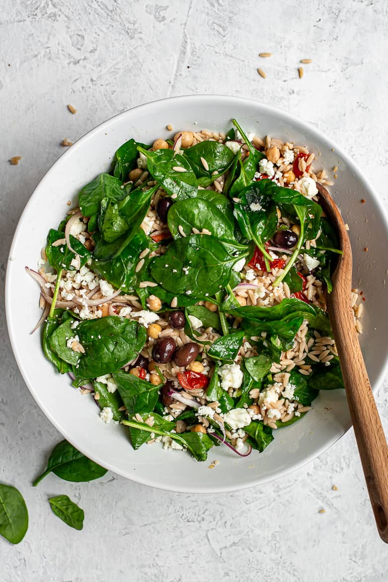 Warm Orzo and chickpea salad with spinach in bowl