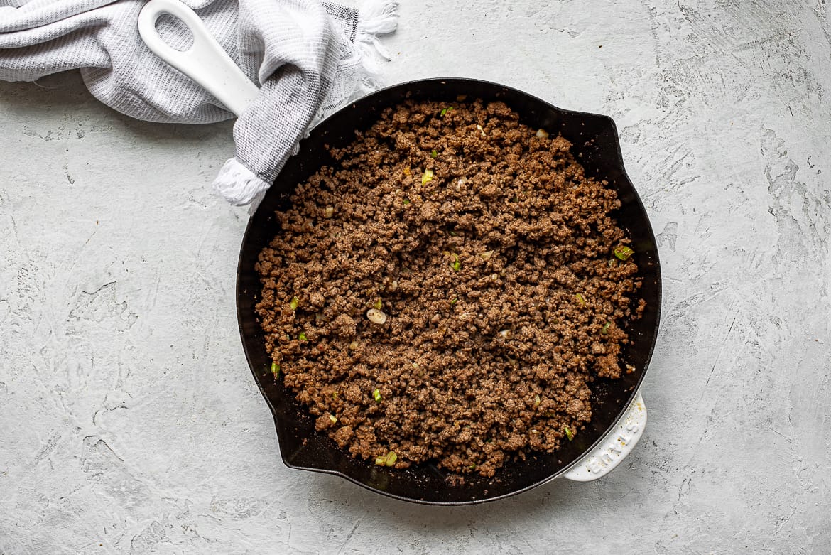 browned beef in skillet with Asian soy-based sauce