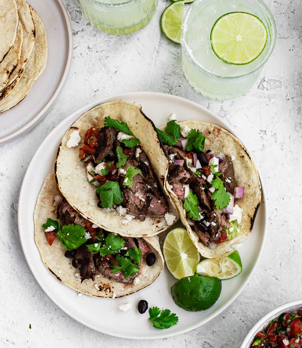 Three Steak street tacos assembled with margarita drinks 