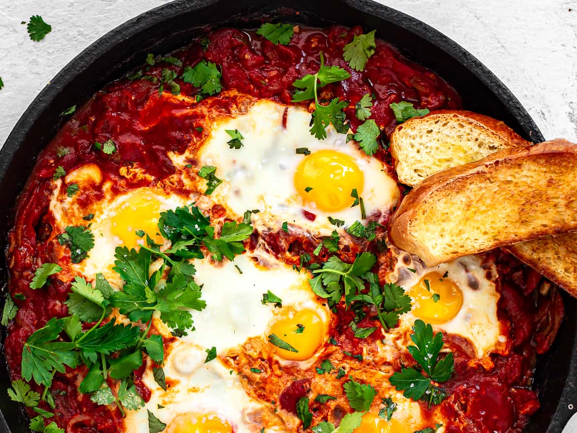 Closeup of Shakshuka in skillet with challah