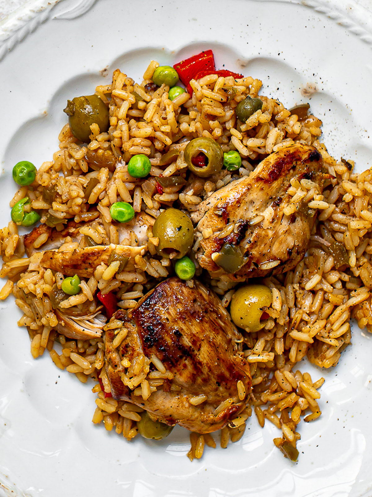 close up of cooked arroz con pollo served on a white plate 