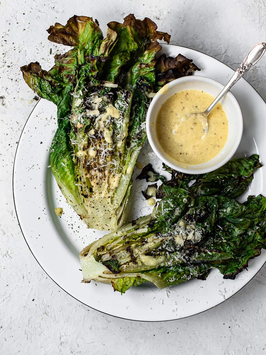 Grilled Romaine hearts on platter with caesar dressing