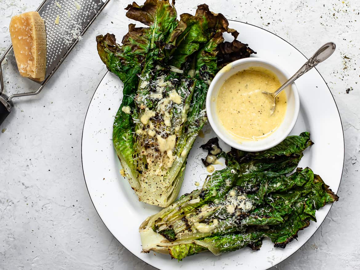 Grilled Romaine hearts on platter with caesar dressing