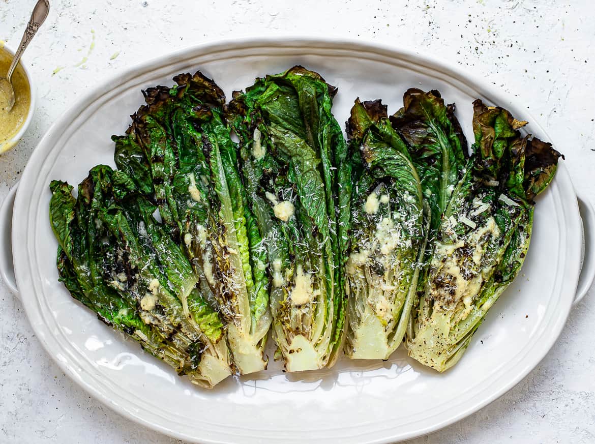 Grilled Romaine hearts on platter with caesar dressing