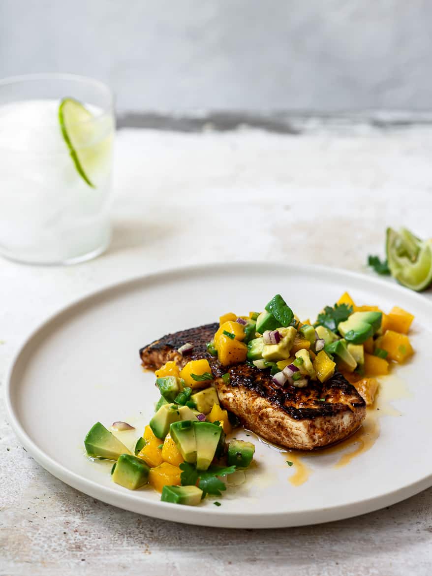 side view of blackened fish with mango salsa plate