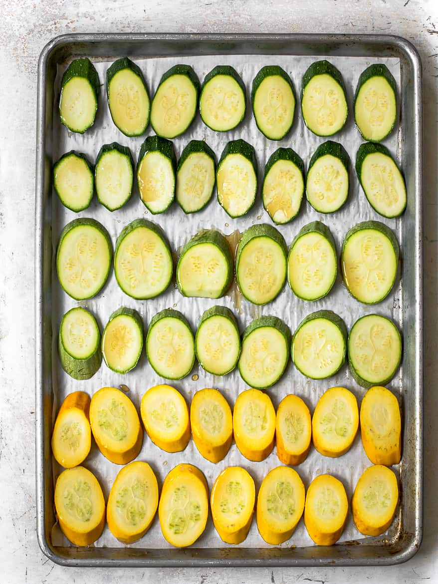 Sliced Zucchini and summer squash on baking tray with honey