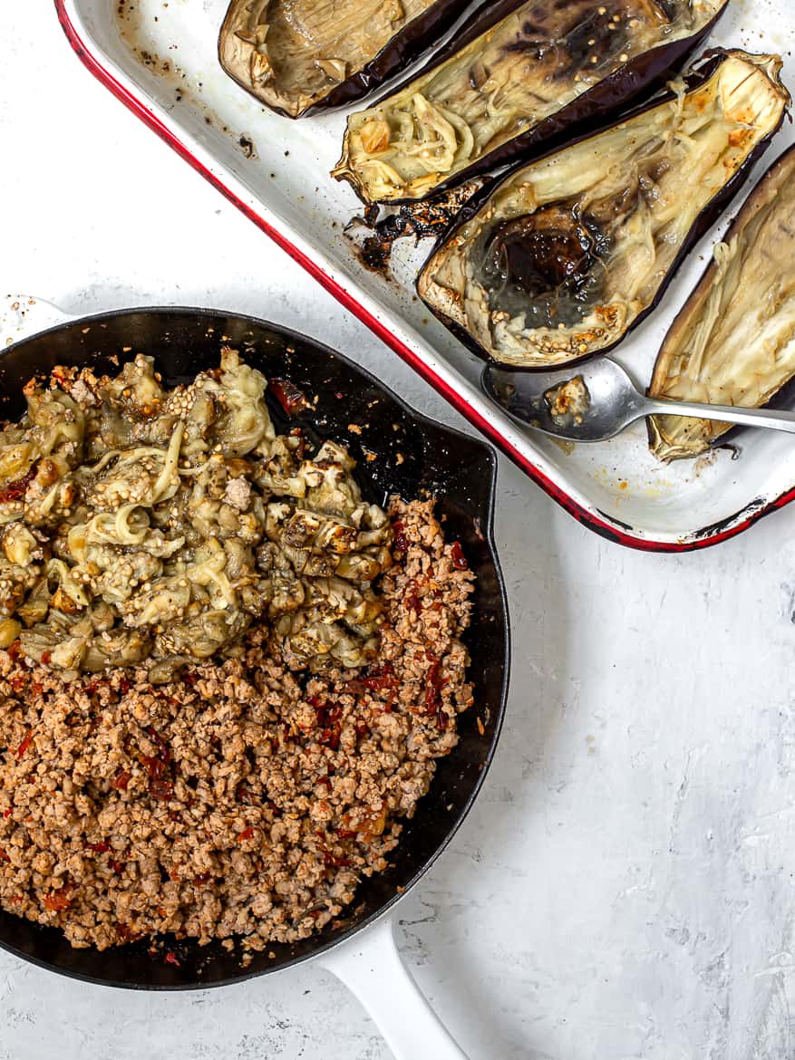 Scooping out eggplant flesh and adding to turkey mixture