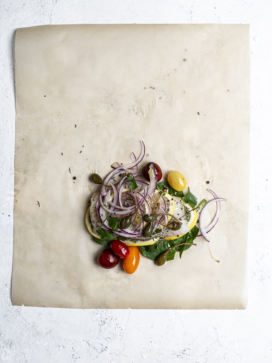 layering ingredients for fish in parchment