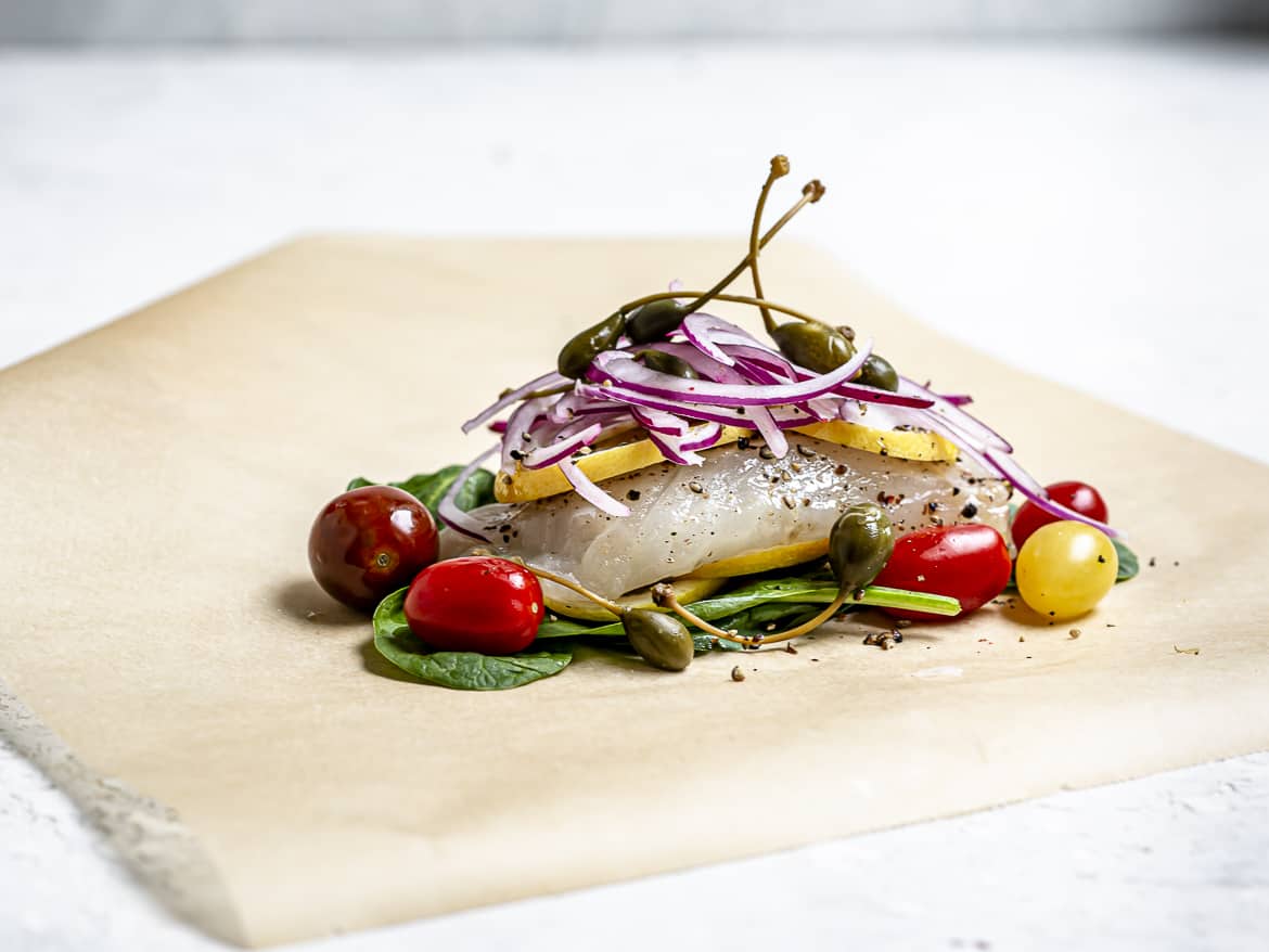 side view of layered ingredients for cod in parchment