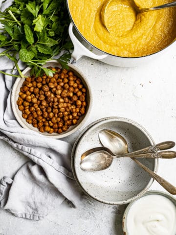 Roasted carrot soup in pot with bowl of crispy chickpeas