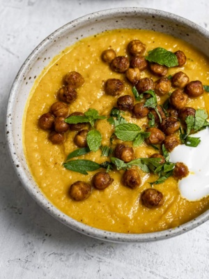 Close up of Roasted Carrot soup topped with crispy chickpeas in bowl