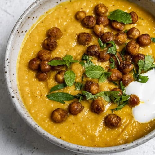 Close up of Roasted Carrot soup topped with crispy chickpeas in bowl