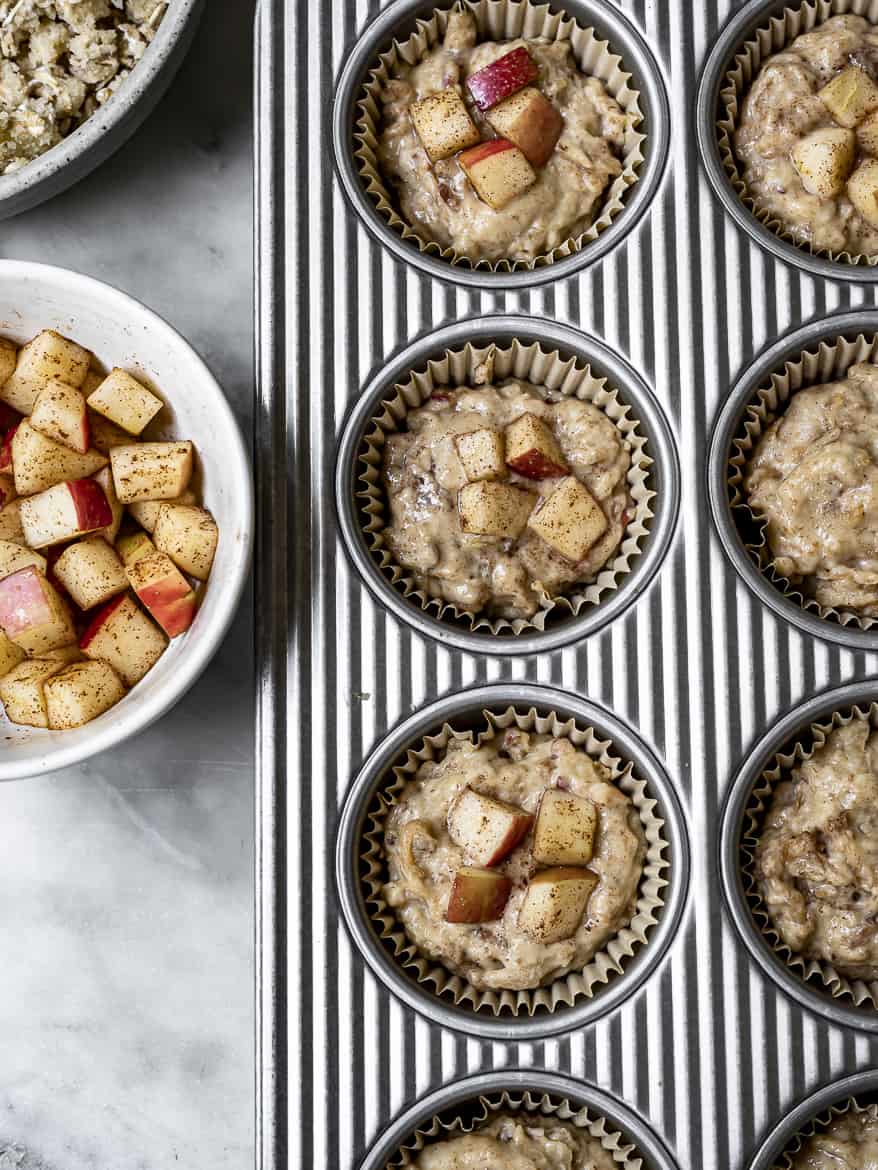 Apple muffins in muffin tin topped with diced apples