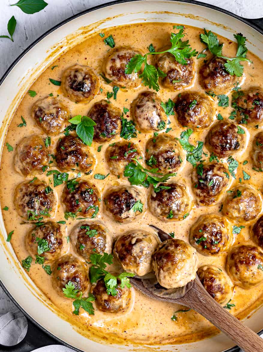 Scooping out Chicken Meatballs with Thai curry Sauce in pan