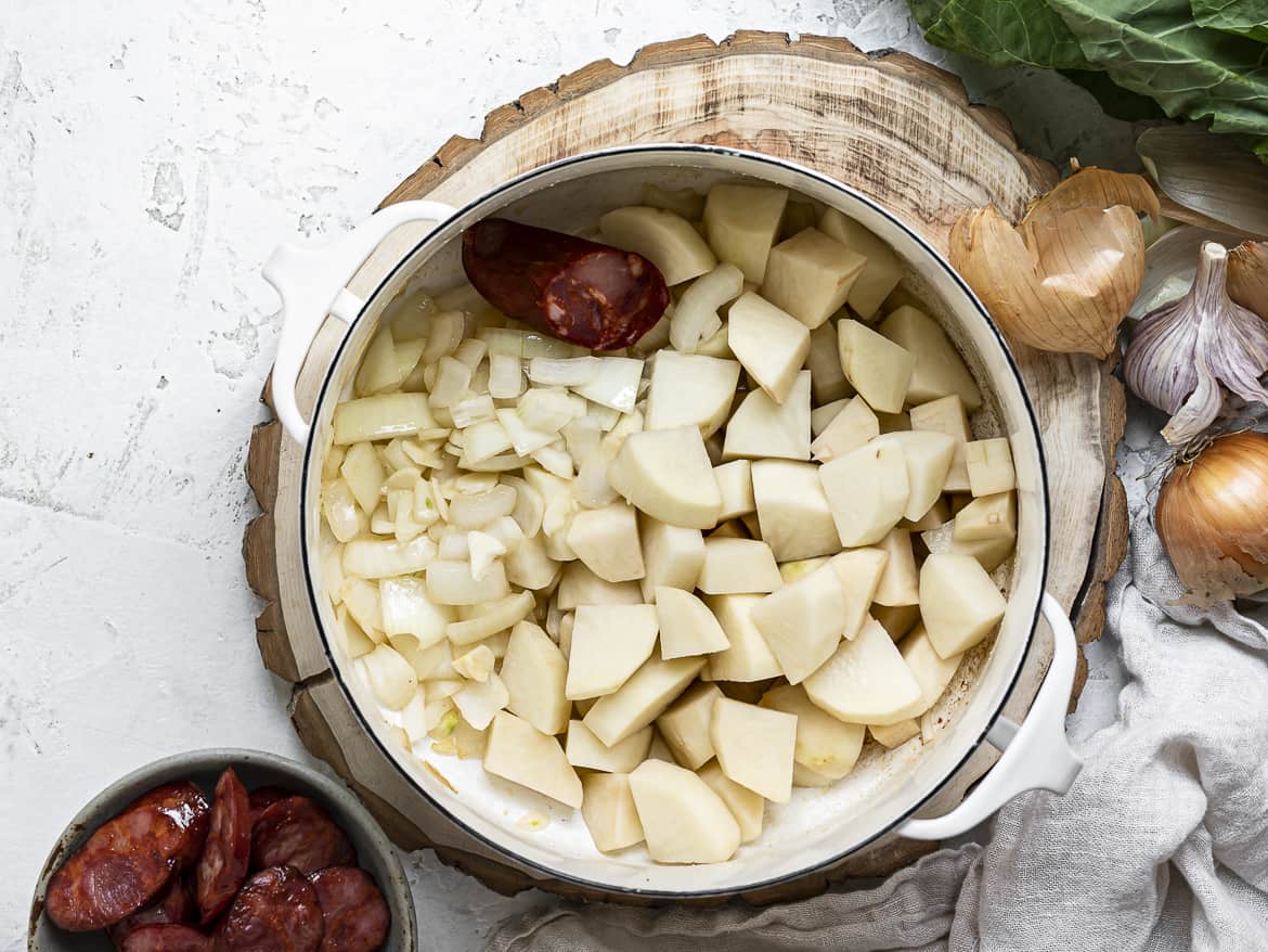 chopped onion, potatoes, and garlic in soup pot