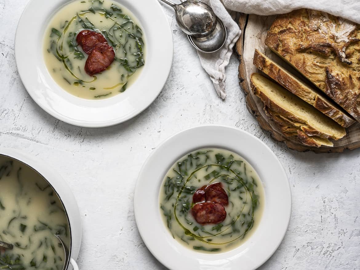 Portuguese caldo verde in bowls with corn bread slices