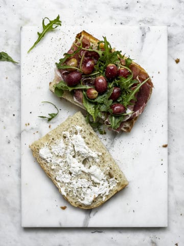 making grape, burrata and arugula focaccia sandwich 