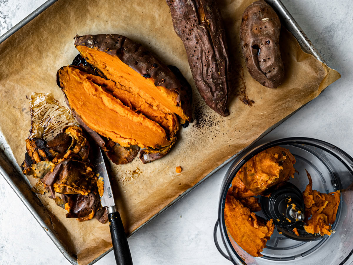 Peeling sweet potatoes and adding flesh to food processor