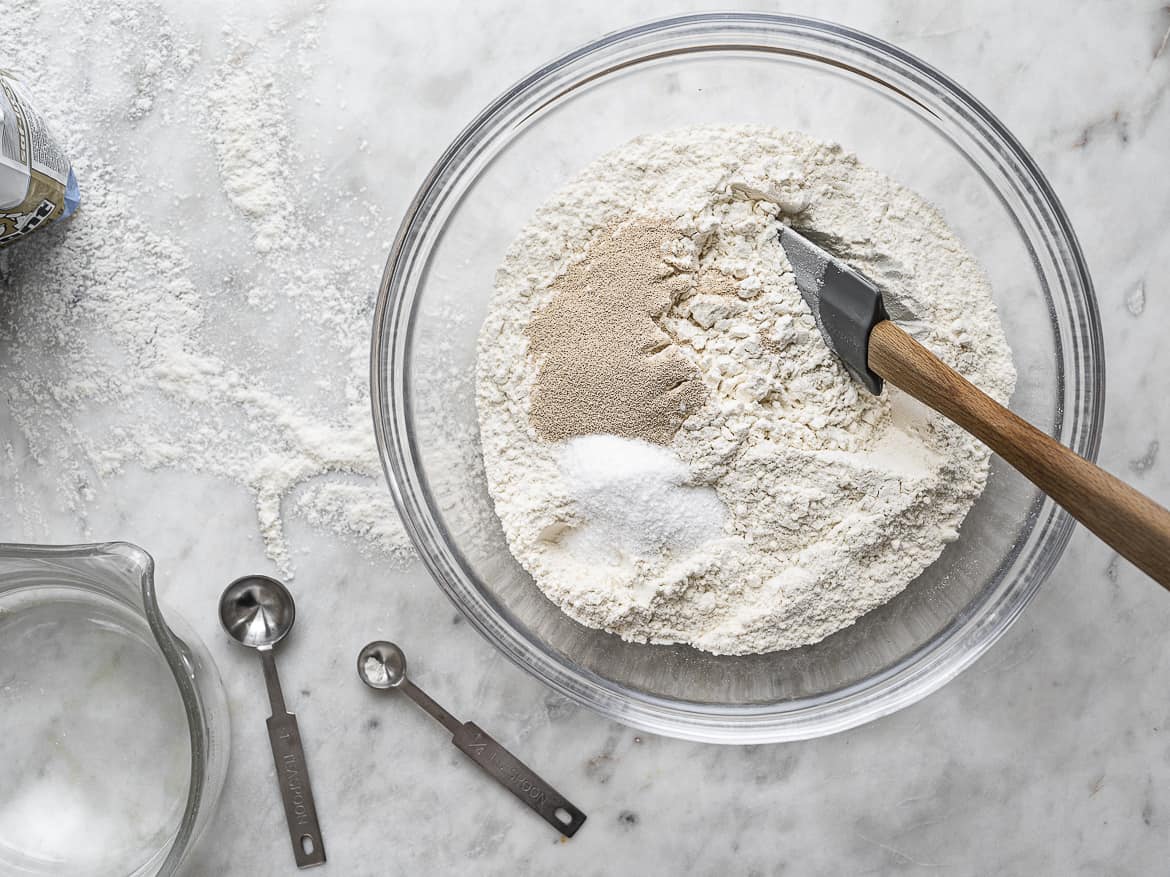 Mixing dry ingredients for focaccia in bowl