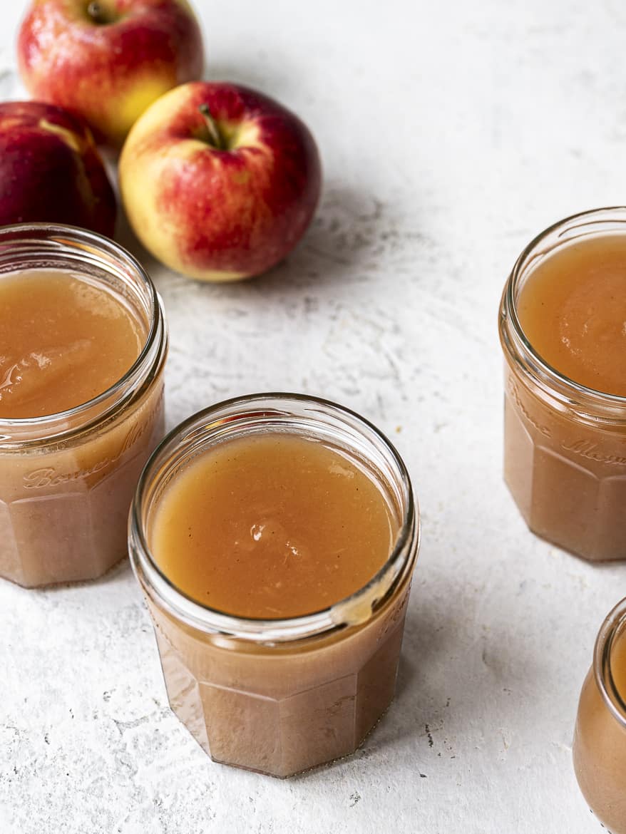 Top view of Instant Pot Applesauce in jars and apples in background